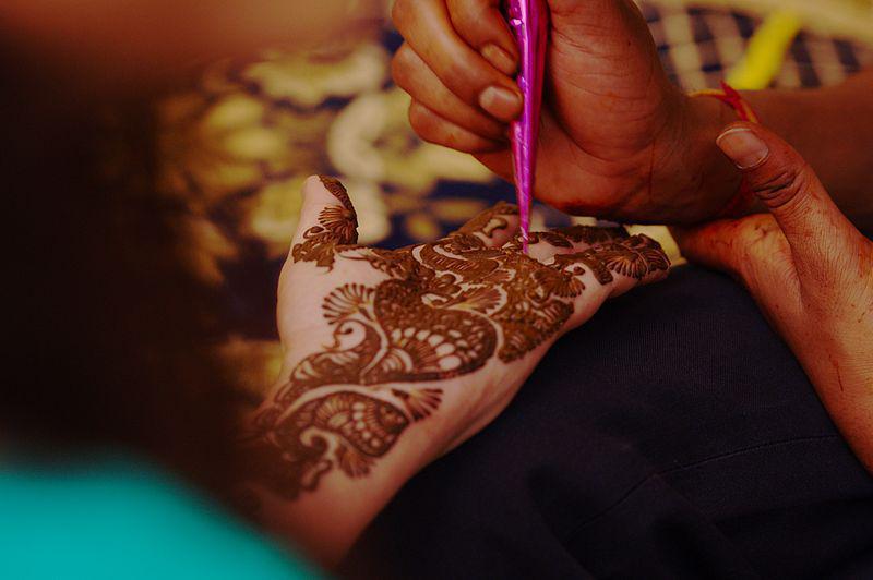A mehndi artist applying mehndi. Mehndi is another term for henna. Henna art is commonly referred to as "mehndi" in South Asian countries such as India.