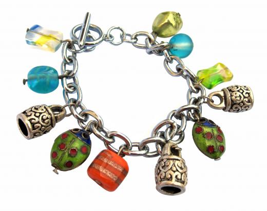 A charm bracelet with tiny ladybugs and other small, colorful charms.