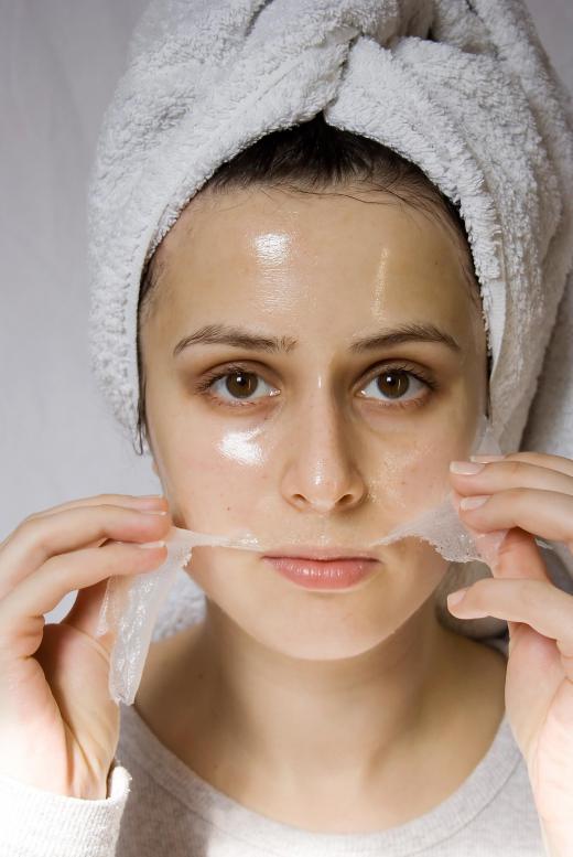 A woman removing a peel-off firming mask.