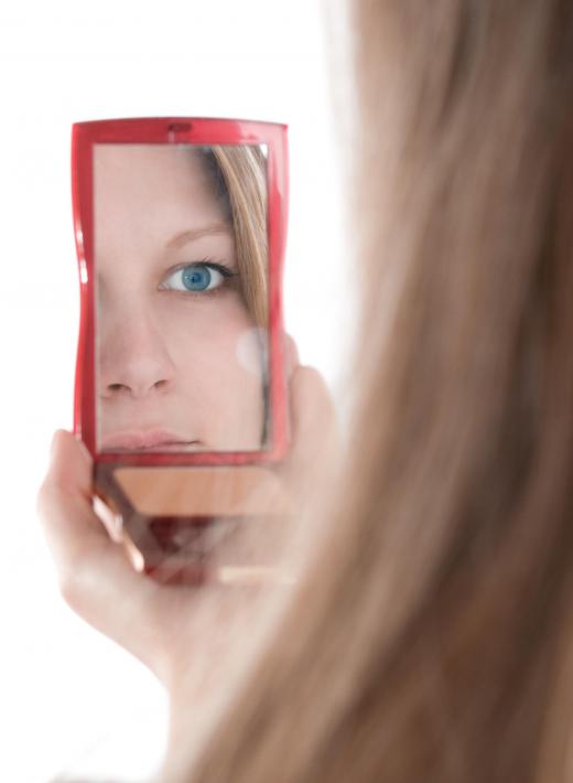 A woman looking in a compact mirror.