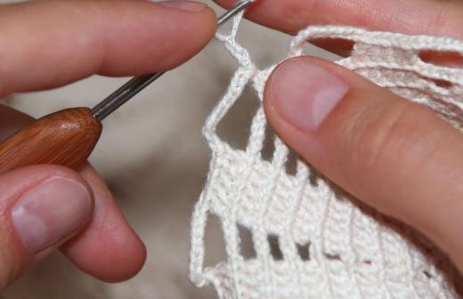 One style of hair bun cover is created by crocheting yarn.