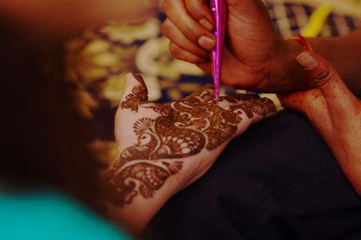 A mehndi artist applying mehndi. Mehndi is another term for henna. Henna art is commonly referred to as "mehndi" in South Asian countries such as India.