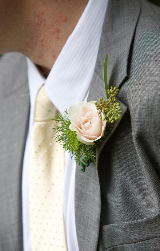 Grooms may wear a boutonniere, or a male version of a corsage, on their wedding day.