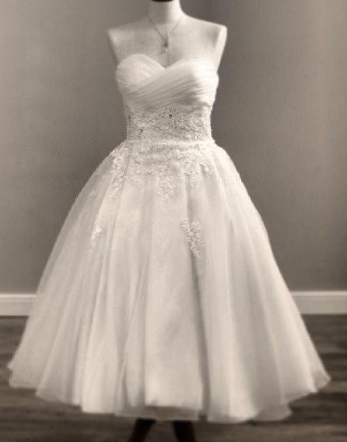 A short fancy white dress with a sweetheart neckline.