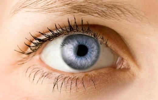 A woman wearing eyelash primer and mascara.